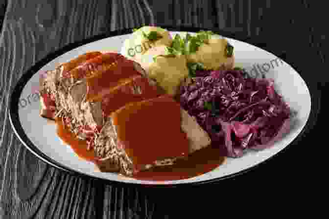 A Plate Of Sauerbraten, A Traditional Bavarian Roast Beef Dish Marinated In Vinegar, Wine, And Spices, Served With Potato Dumplings And Red Cabbage. German Food: Traditional Cuisine Dishes In Germany: Northern German Cuisine
